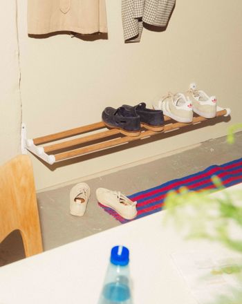 An industrial hallway with Nostalgi hat & shoe rack in marine bamboo and white used as a shoe rack