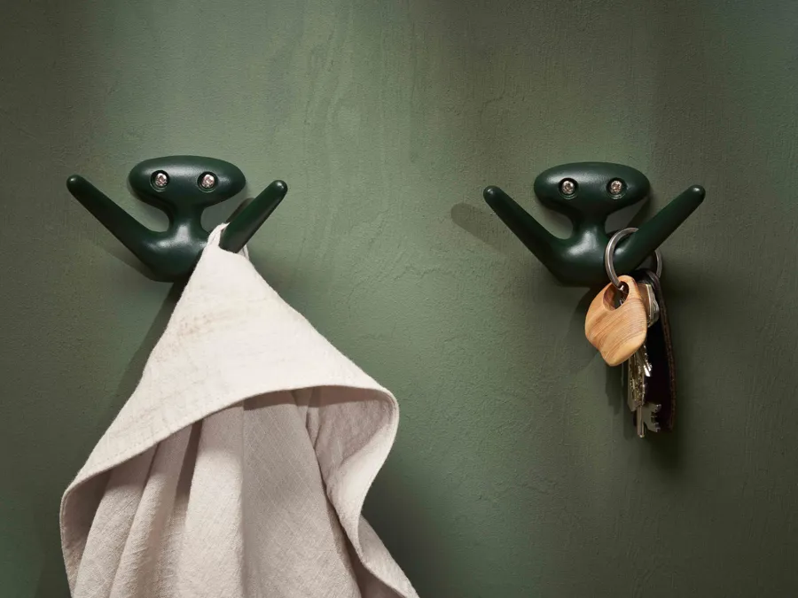 The Mama hook in a fir green color on a green wall support both clothes and keys.