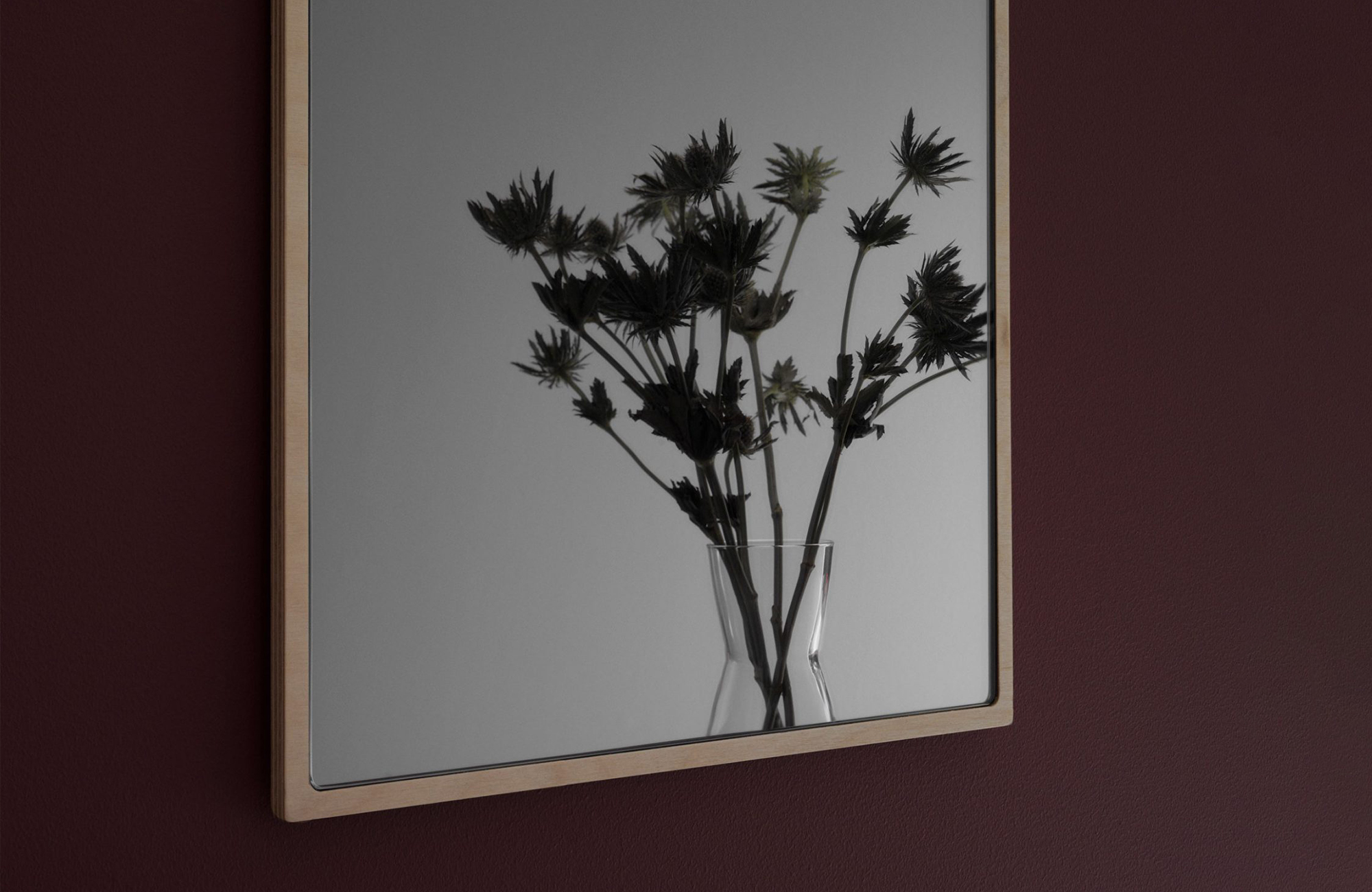 Tillbakablick mirror in birch reflecting flowers in a vase
